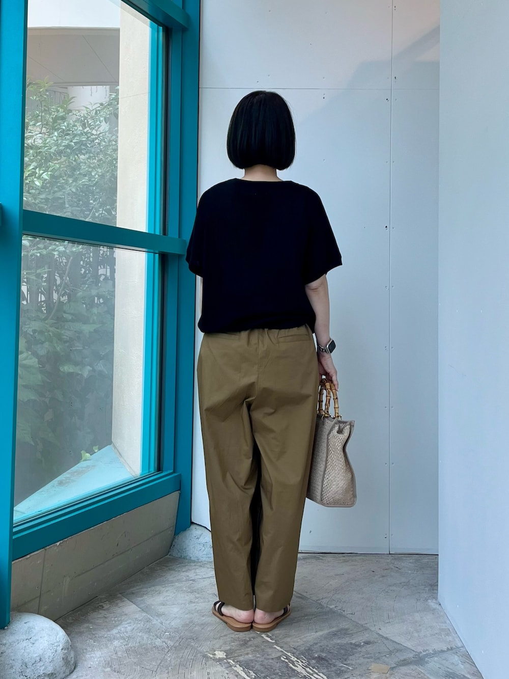 ブラック系のニット/セーター、ベージュ系のその他パンツ、ベージュ系のショルダーバッグを着用したレディースの夏コーディネートの5枚目の写真
