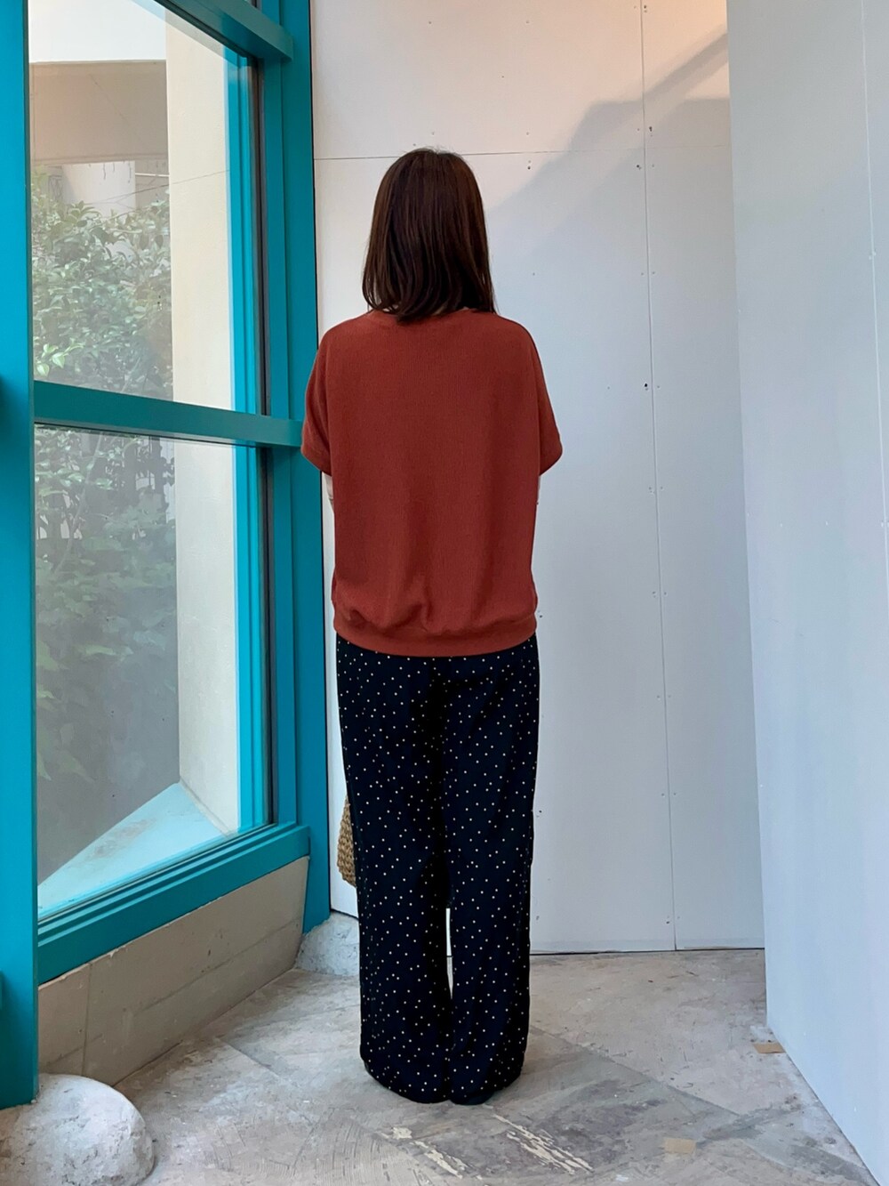 オレンジ系のTシャツ/カットソー、イエロー系のトートバッグ、ブラック系のその他パンツを着用したレディースの夏コーディネートの4枚目の写真