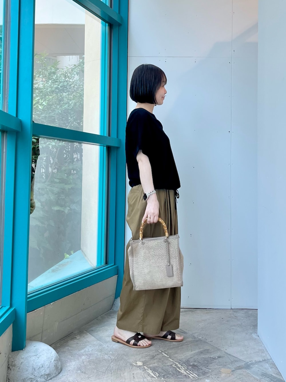 ブラック系のニット/セーター、ベージュ系のその他パンツ、ベージュ系のショルダーバッグを着用したレディースの夏コーディネートの2枚目の写真