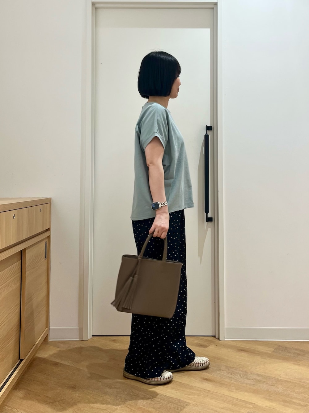 グレー系のトートバッグ、グリーン系のTシャツ/カットソー、ブルー系のその他パンツを着用したレディースの夏コーディネートの3枚目の写真