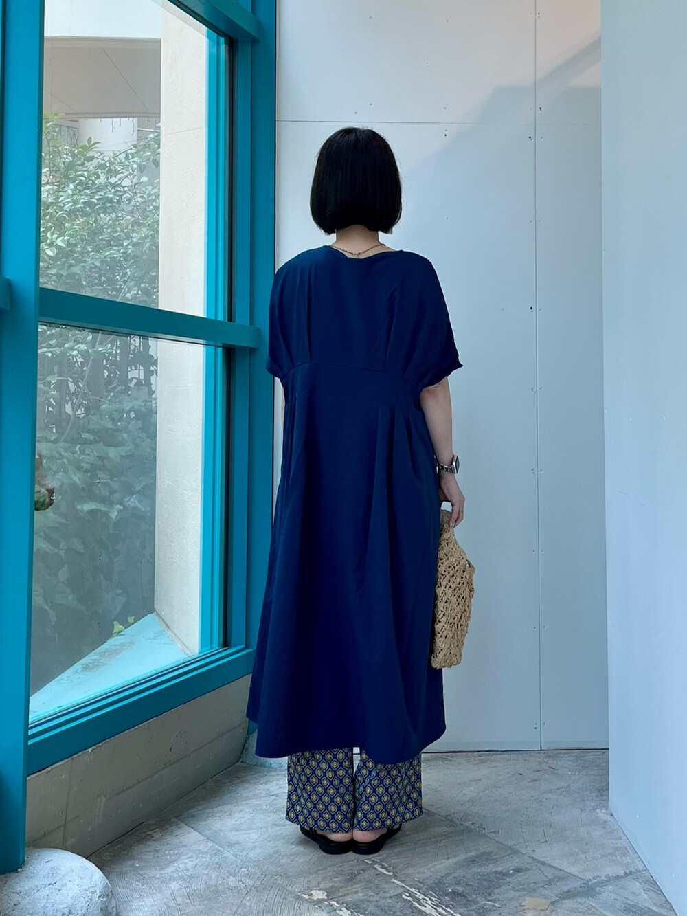ブルー系のワンピース、ベージュ系のハンドバッグ、ブルー系のその他パンツを着用したレディースの夏コーディネートの4枚目の写真