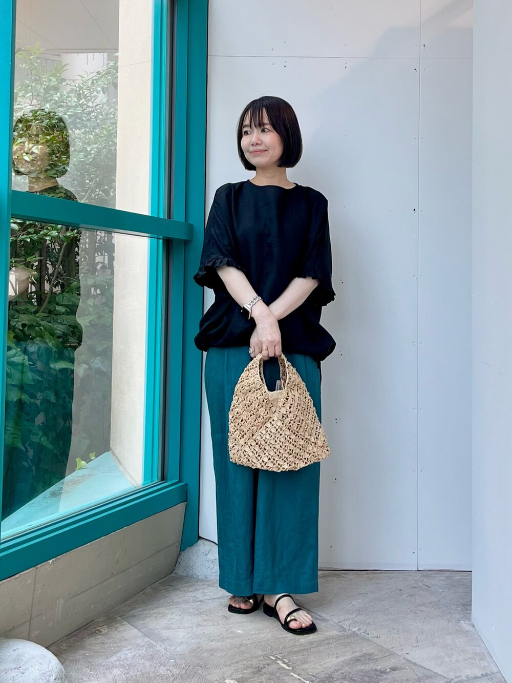 ブラック系のシャツ/ブラウス、ブルー系のその他パンツ、ベージュ系のハンドバッグを着用したレディースの夏コーディネートの2枚目の写真