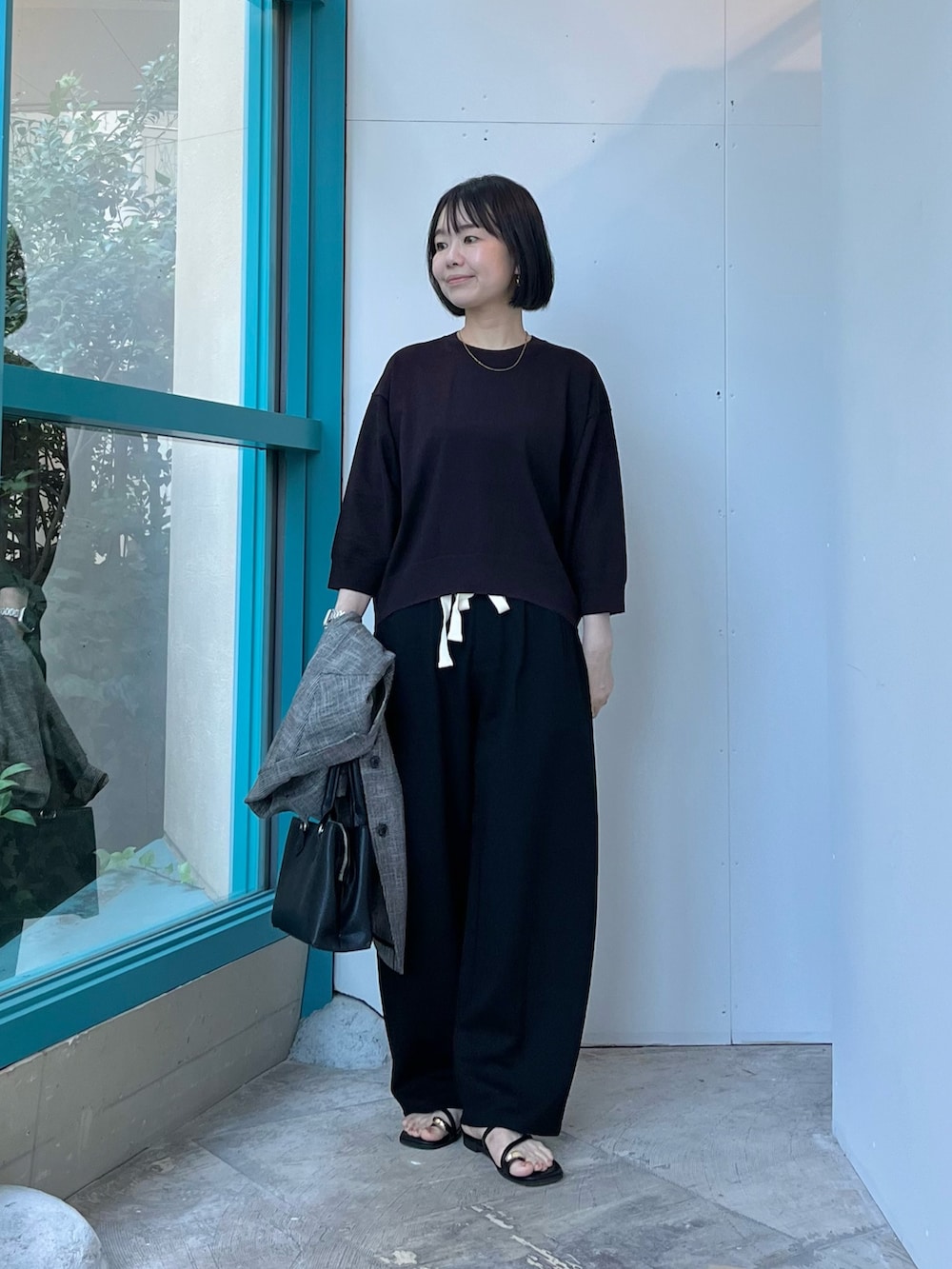 ブラック系のハンドバッグ、ブラック系のサンダル、ブラック系のその他パンツを着用したレディースの夏コーディネートの4枚目の写真