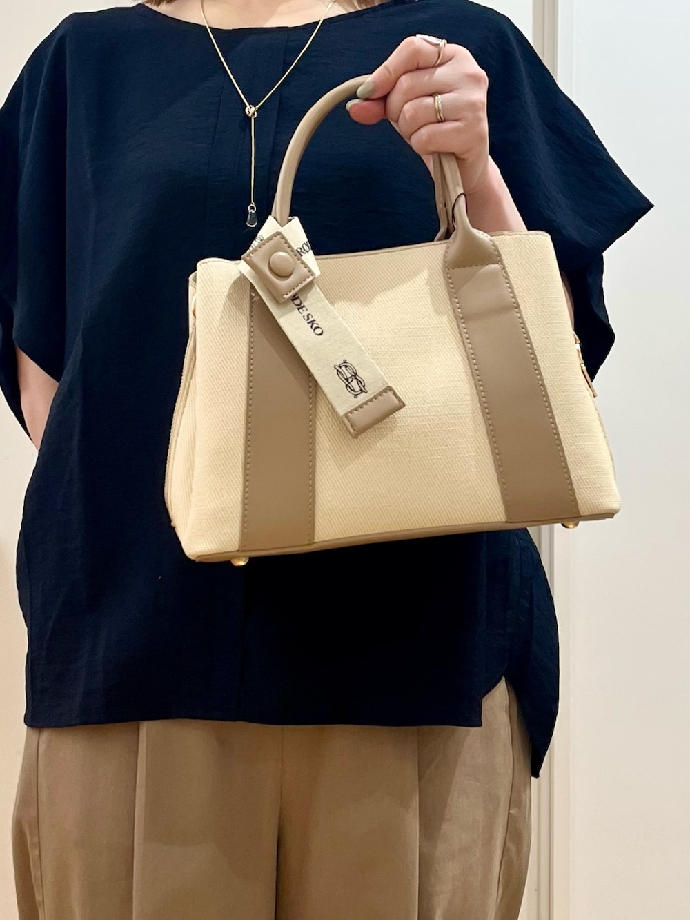 ブルー系のシャツ/ブラウス、ベージュ系のその他パンツ、ホワイト系のハンドバッグを着用したレディースの夏コーディネートの3枚目の写真