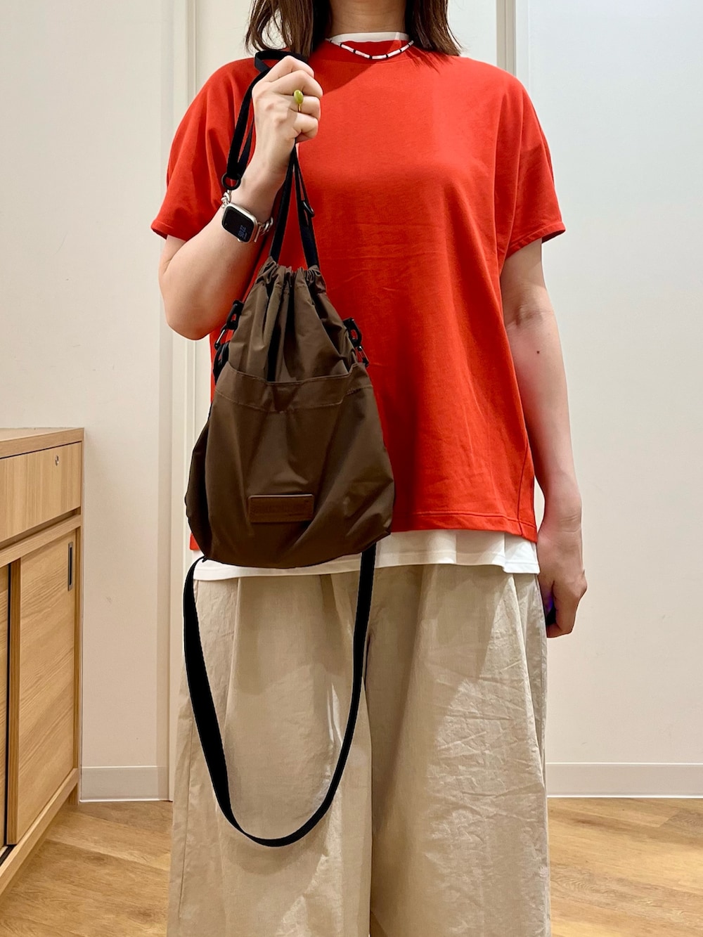 レッド系のTシャツ/カットソー、ホワイト系のTシャツ/カットソー、ブラウン系のショルダーバッグを着用したレディースの夏コーディネートの6枚目の写真