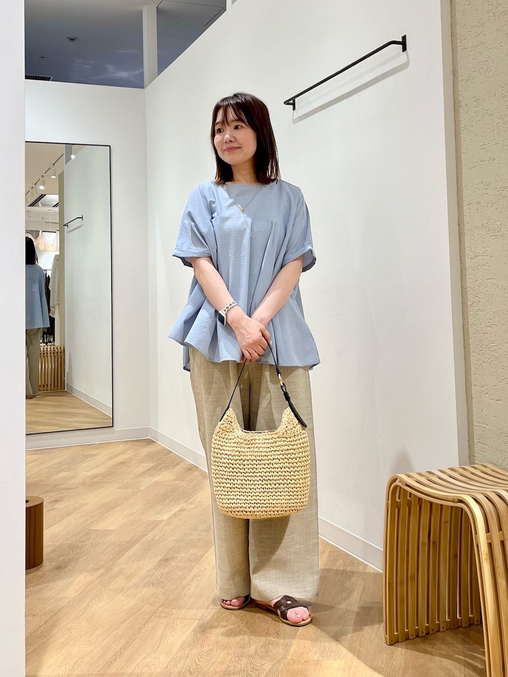 ベージュ系のその他パンツ、ブラウン系のサンダル、ブルー系のシャツ/ブラウスを着用したレディースの夏コーディネートの3枚目の写真