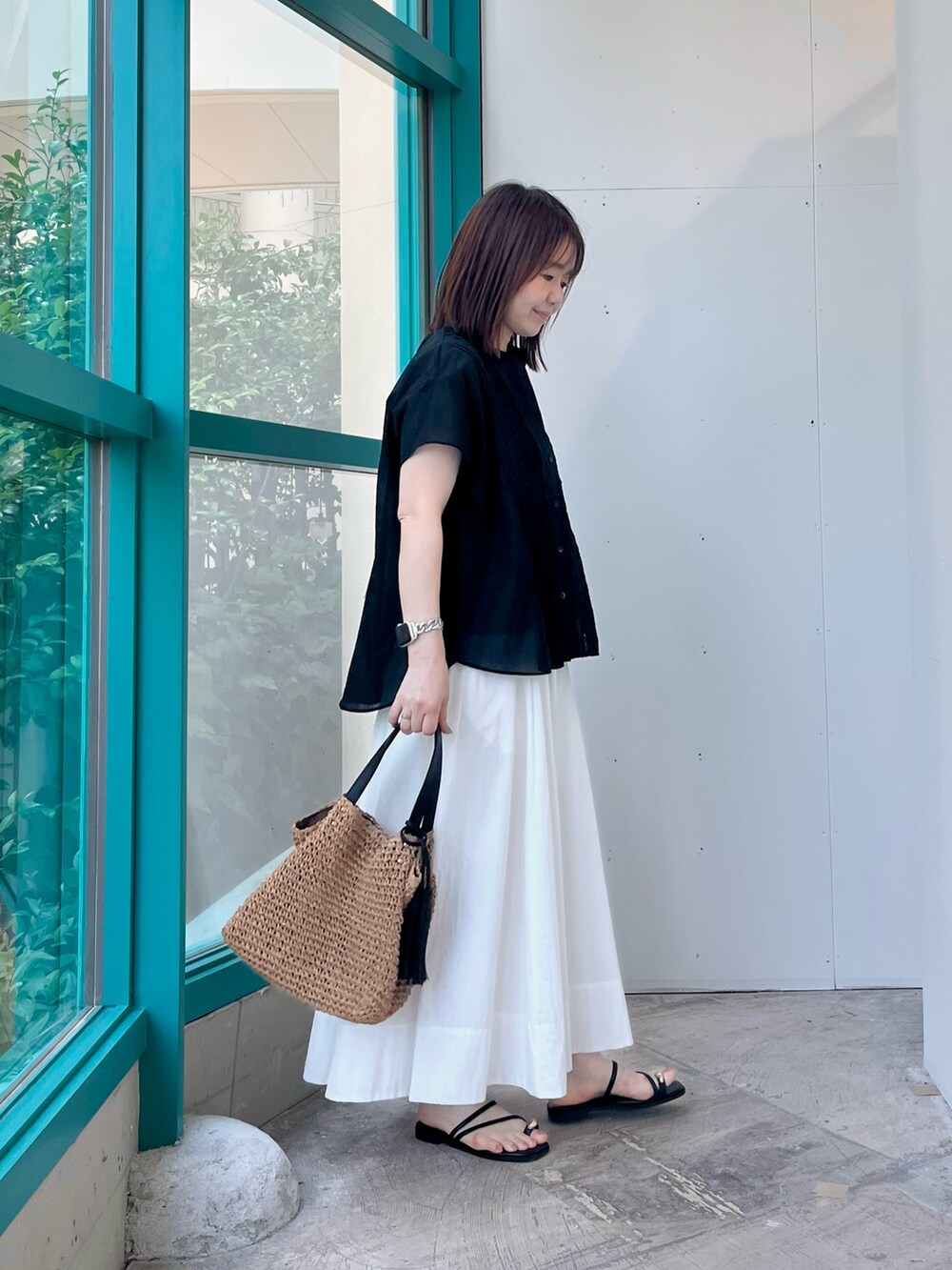 ブラック系のシャツ/ブラウス、ホワイト系のスカート、イエロー系のトートバッグを着用したレディースの夏コーディネートの2枚目の写真