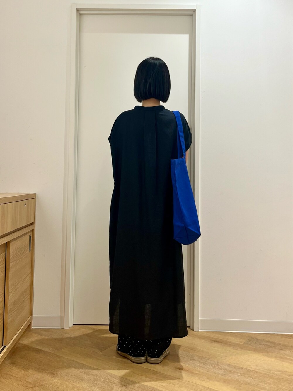 ブラック系のワンピース、ブルー系のトートバッグ、ブルー系のその他パンツを着用したレディースの夏コーディネートの5枚目の写真