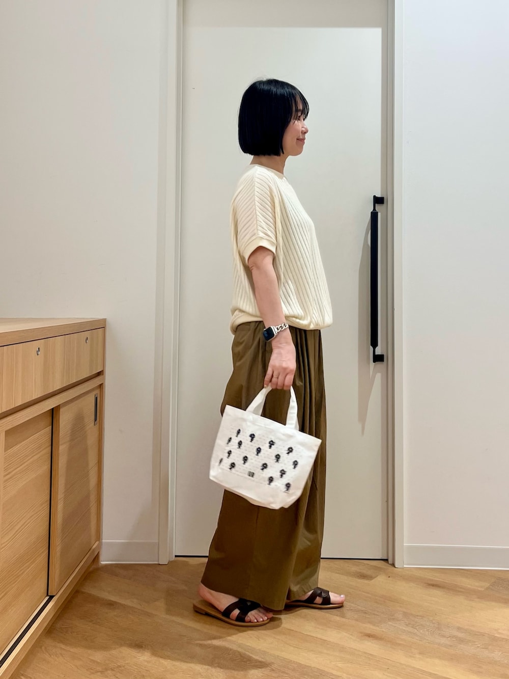 ホワイト系のTシャツ/カットソー、ベージュ系のその他パンツ、ブラウン系のサンダルを着用したレディースの夏コーディネートの2枚目の写真