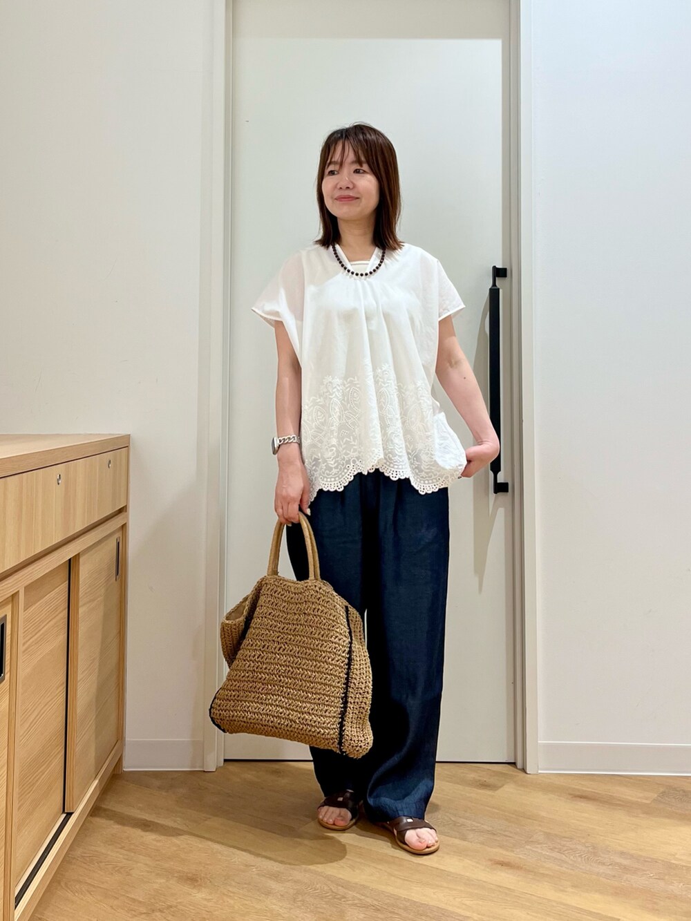 ホワイト系のシャツ/ブラウス、ホワイト系のタンクトップ、ブルー系のデニムパンツを着用したレディースの夏コーディネートの3枚目の写真