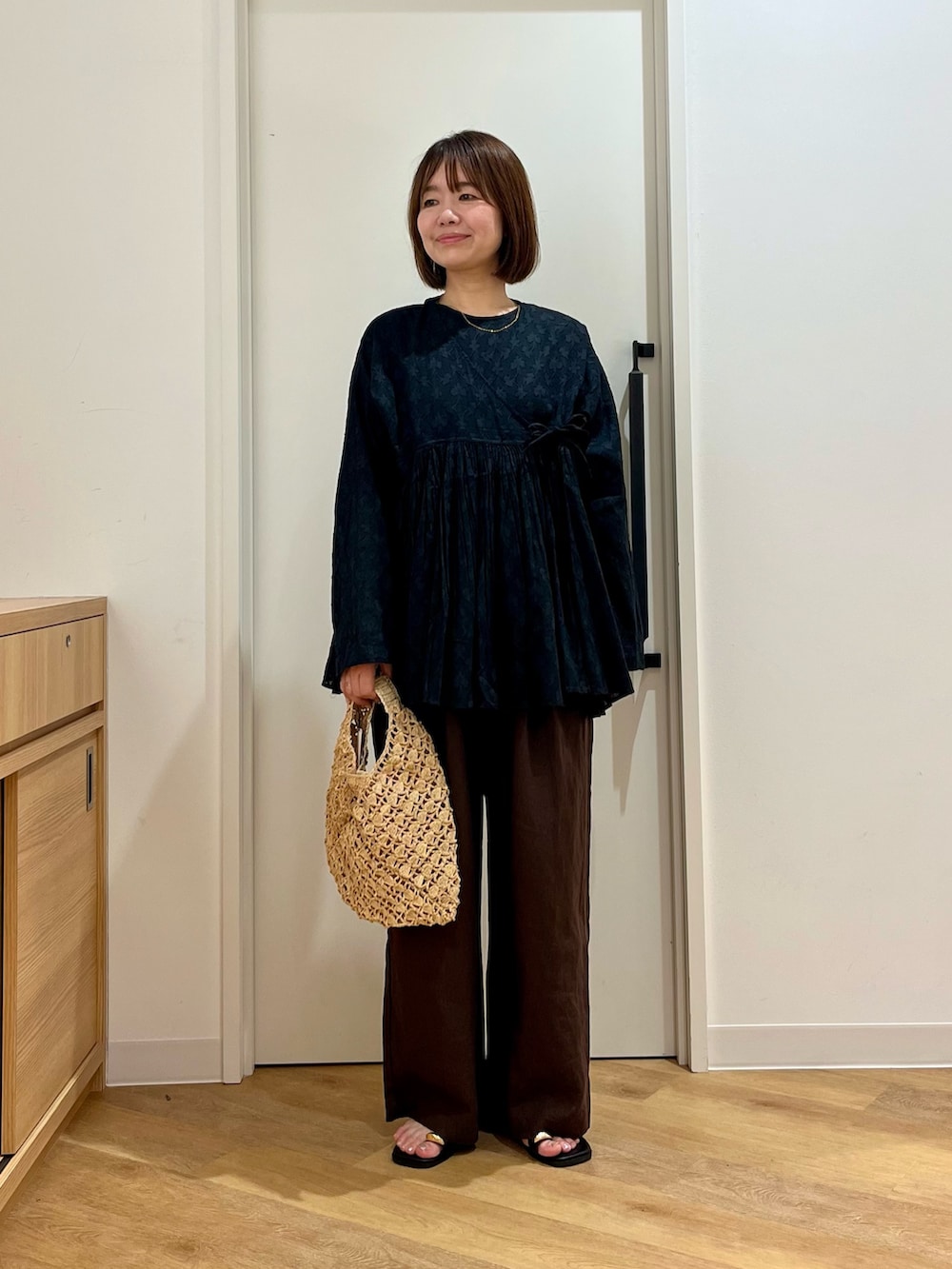 ブラック系のシャツ/ブラウス、ベージュ系のハンドバッグ、ブラウン系のその他パンツを着用したレディースの夏コーディネートの3枚目の写真