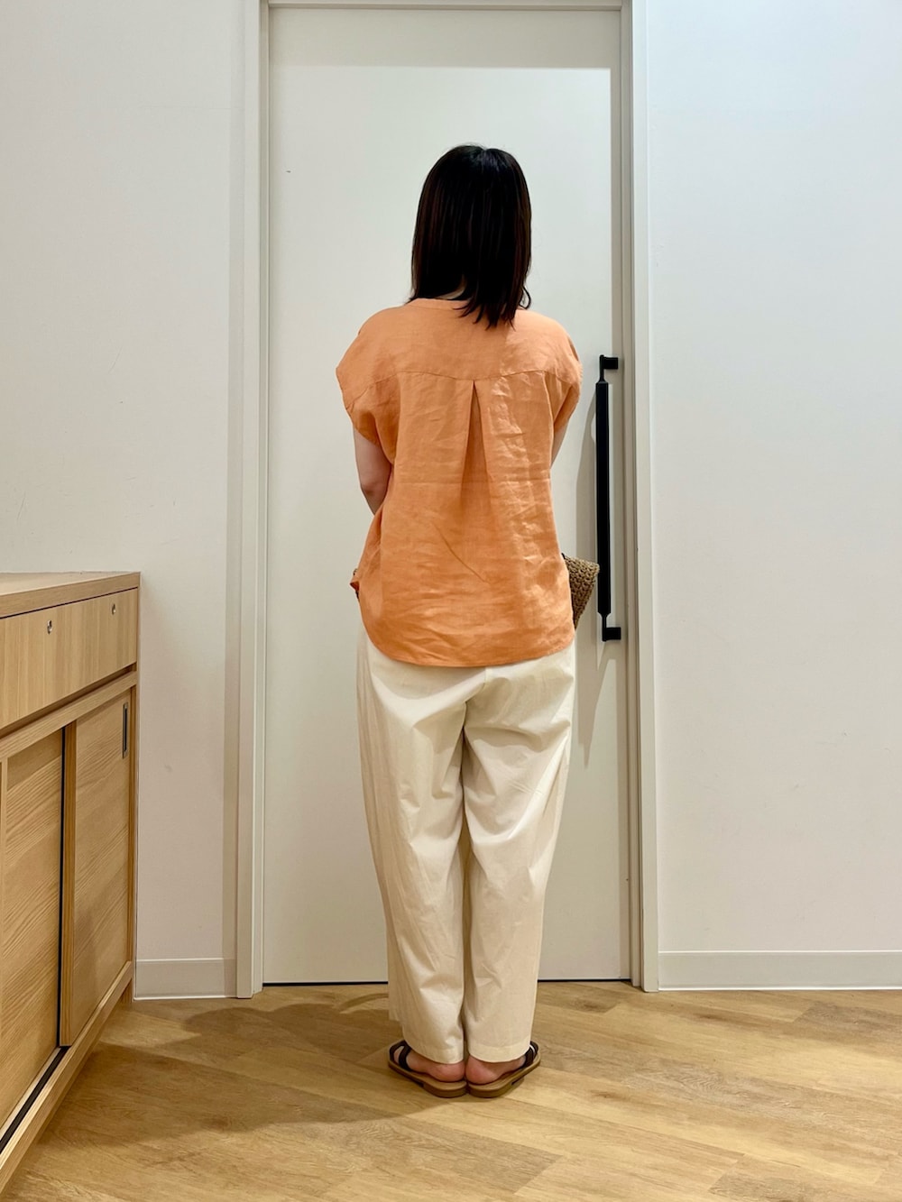 ベージュ系のトートバッグ、ホワイト系のその他パンツ、ブラウン系のサンダルを着用したレディースの夏コーディネートの3枚目の写真