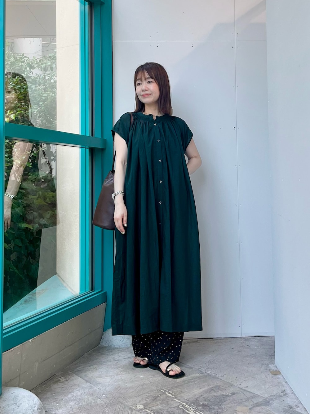 ブラック系のその他パンツ、ブラック系のサンダル、ブラウン系のショルダーバッグを着用したレディースの夏コーディネートの2枚目の写真