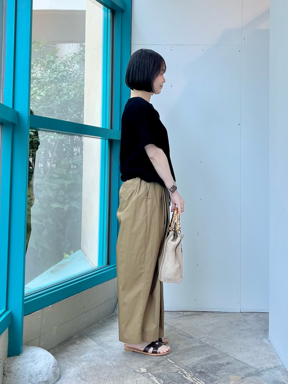 ブラック系のニット/セーター、ベージュ系のその他パンツ、ベージュ系のショルダーバッグを着用したレディースの夏コーディネートの3枚目の写真