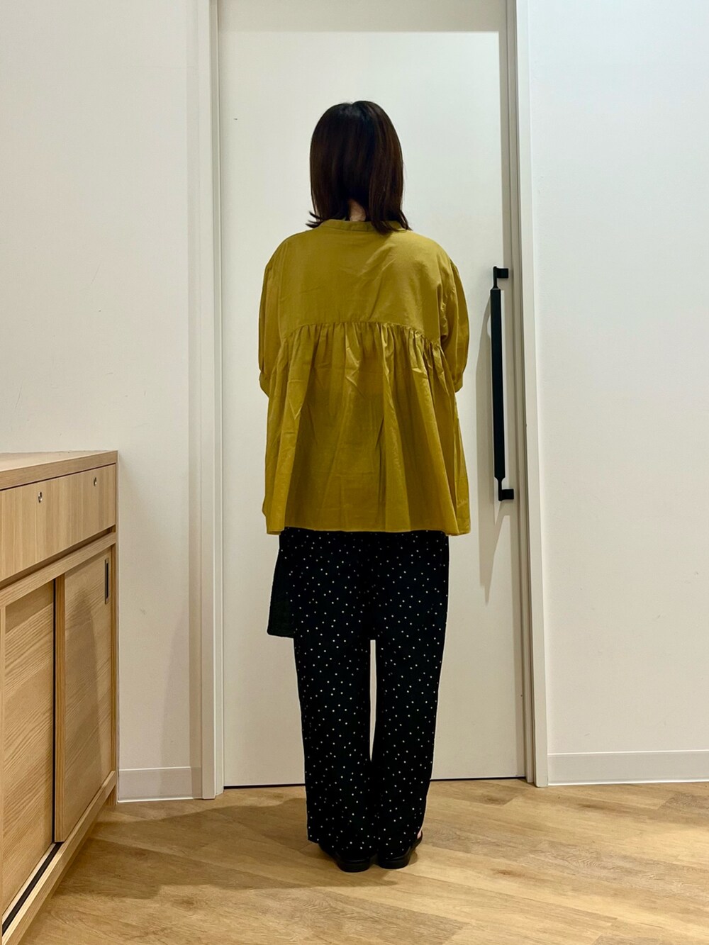 イエロー系のシャツ/ブラウス、ブラック系のその他パンツ、ブラック系のハンドバッグを着用したレディースの夏コーディネートの4枚目の写真