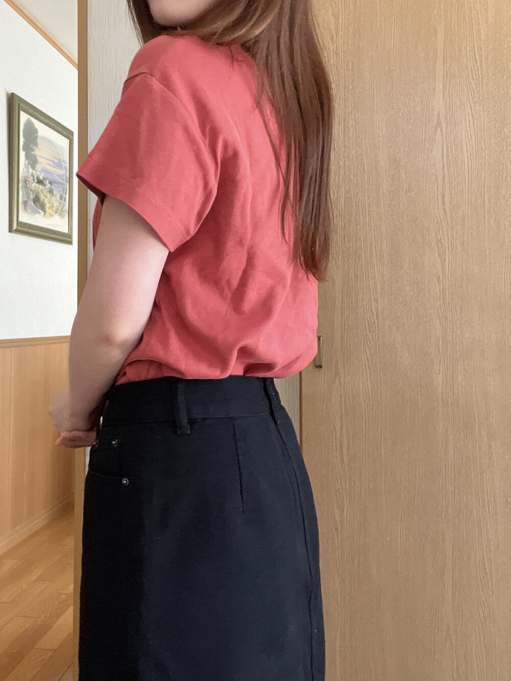 オレンジ系のTシャツ/カットソー、ブラック系のデニムスカートを着用したレディースの夏コーディネートの2枚目の写真