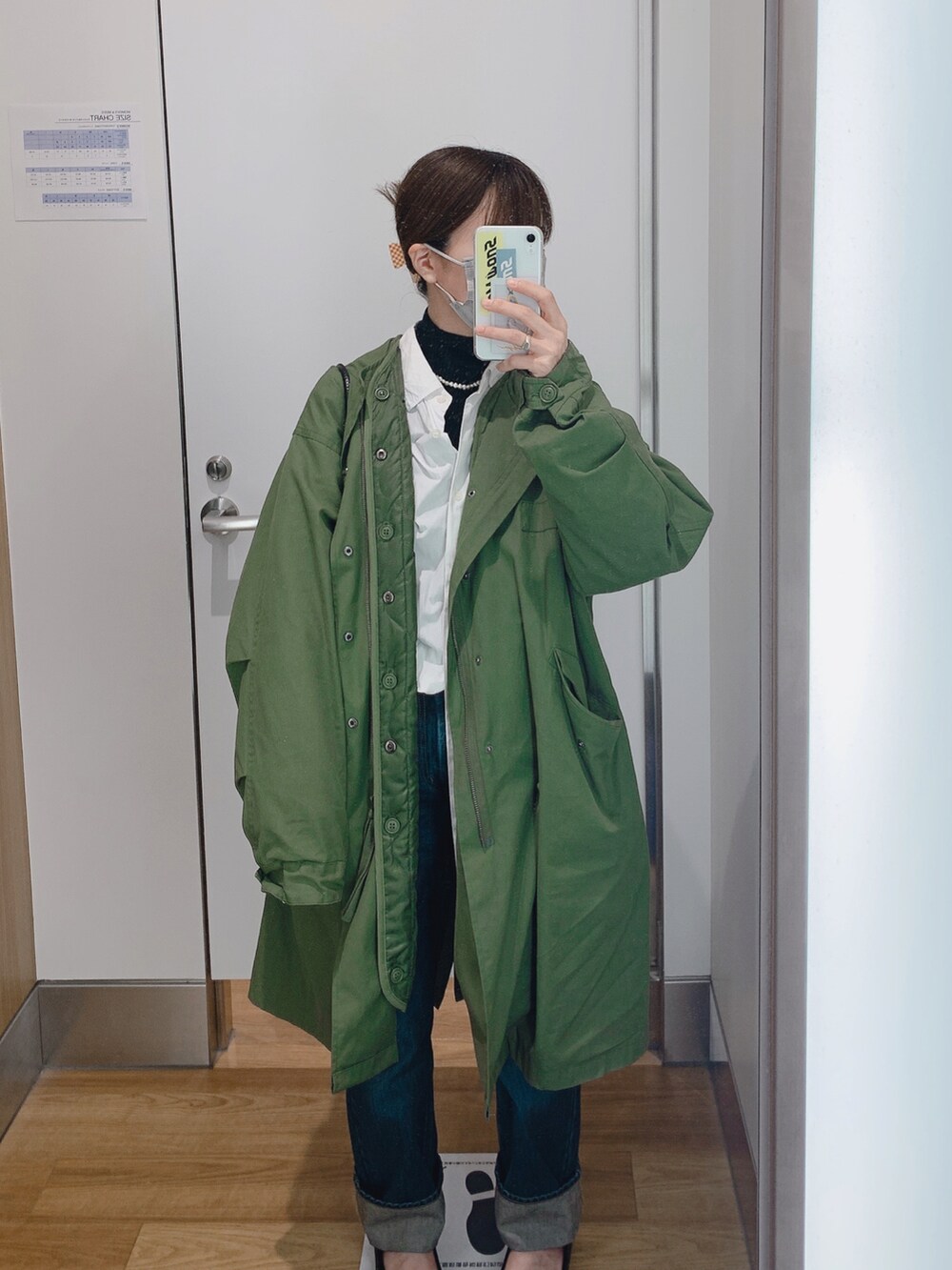 ブルー系のデニムパンツ、グリーン系のモッズコート、ホワイト系のシャツ/ブラウスを着用したレディースの春コーディネートの2枚目の写真