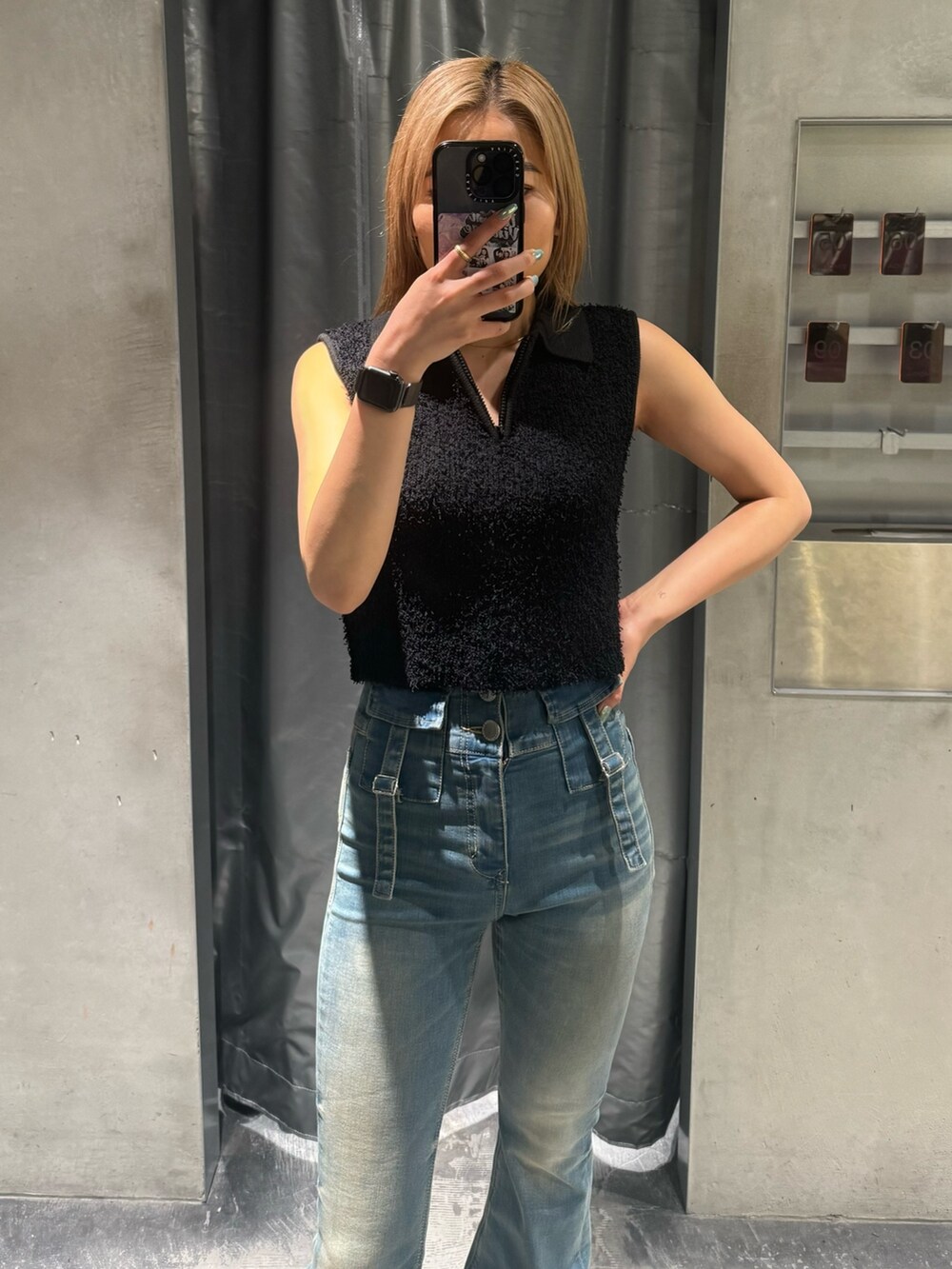 ブラック系のタンクトップ、ブルー系のデニムパンツ、ブラック系のサンダルを着用したレディースの夏コーディネートの5枚目の写真