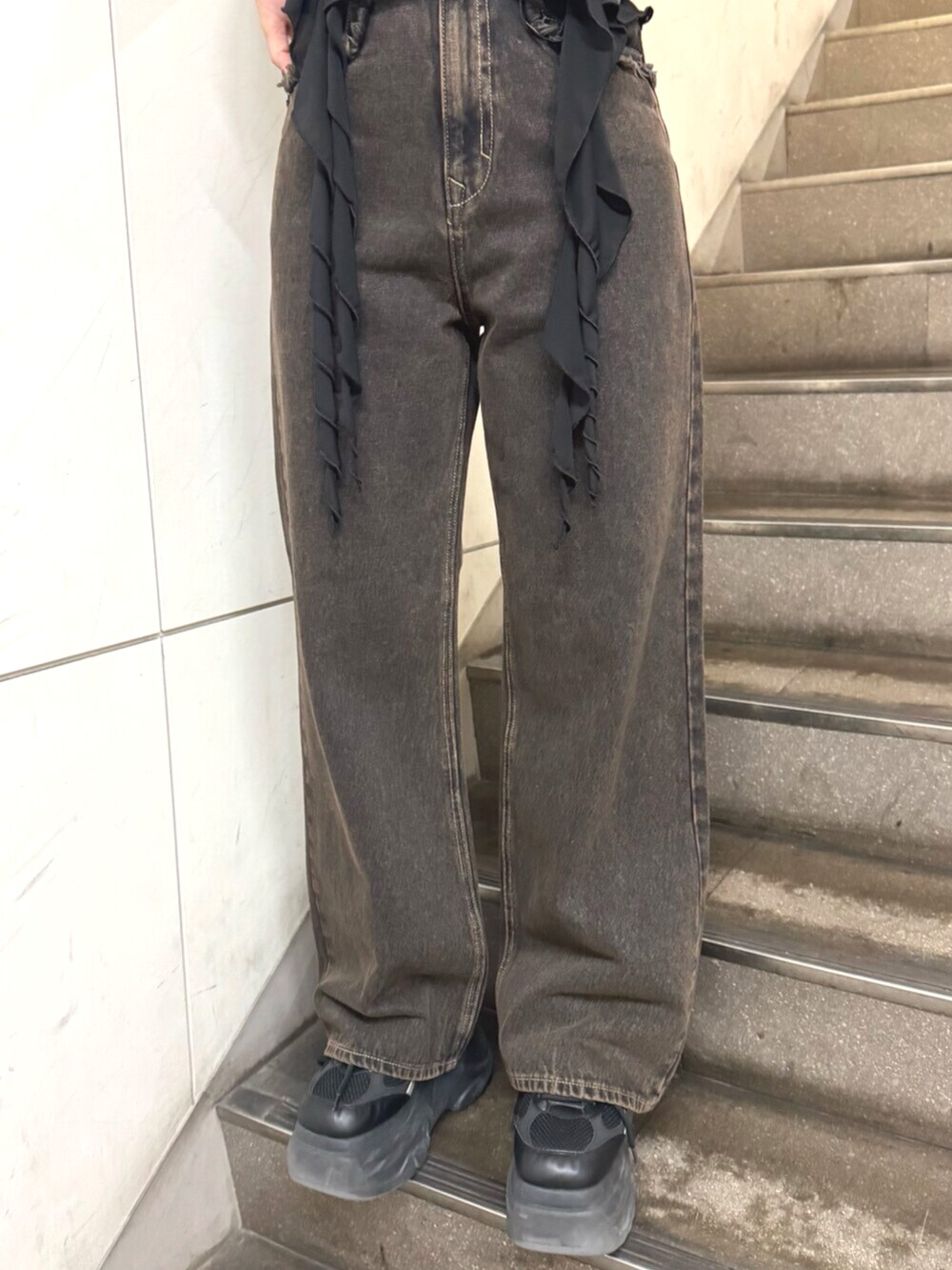 ブラック系のスニーカー、ブラック系のTシャツ/カットソー、ブラック系のデニムパンツを着用したレディースの春コーディネートの5枚目の写真