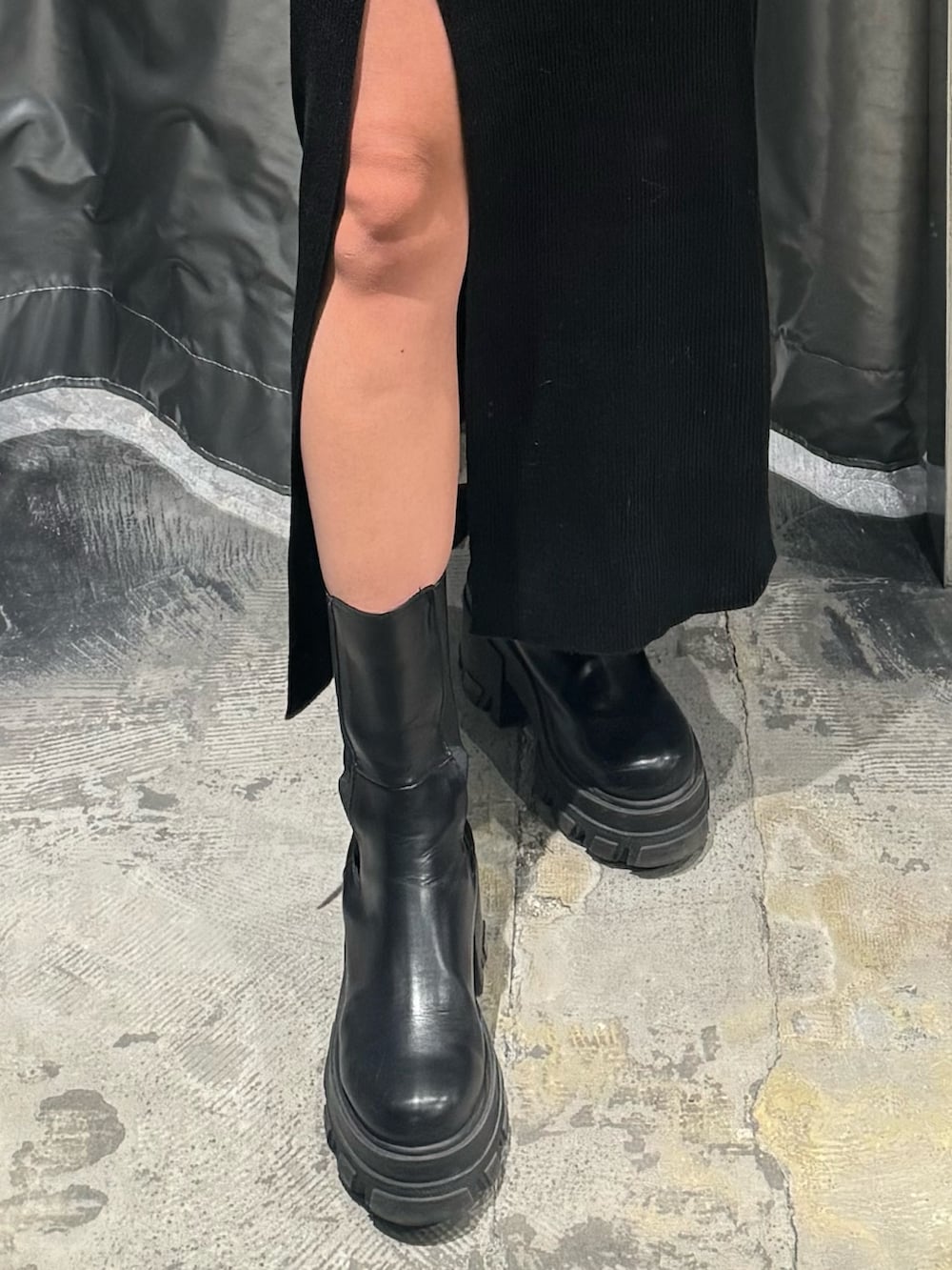 ブラック系のワンピース、ブラック系のブーツを着用したレディースの冬コーディネートの6枚目の写真