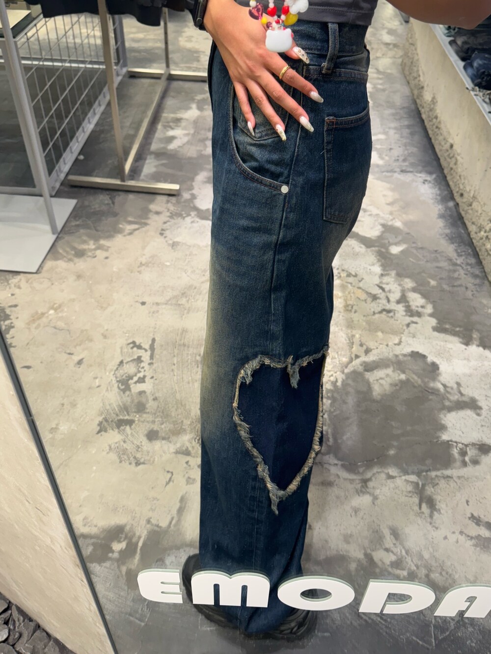 グレー系のTシャツ/カットソー、ブルー系のデニムパンツ、ブラック系のスニーカーを着用したレディースの秋コーディネートの6枚目の写真