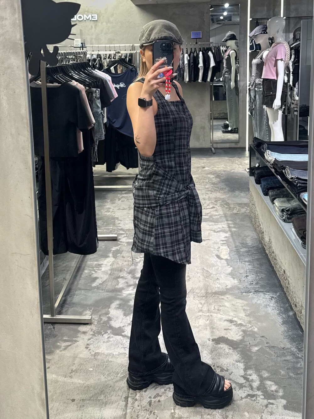 グレー系のワンピース、ブラック系のデニムパンツ、ブラック系のサンダルを着用したレディースの夏コーディネートの2枚目の写真