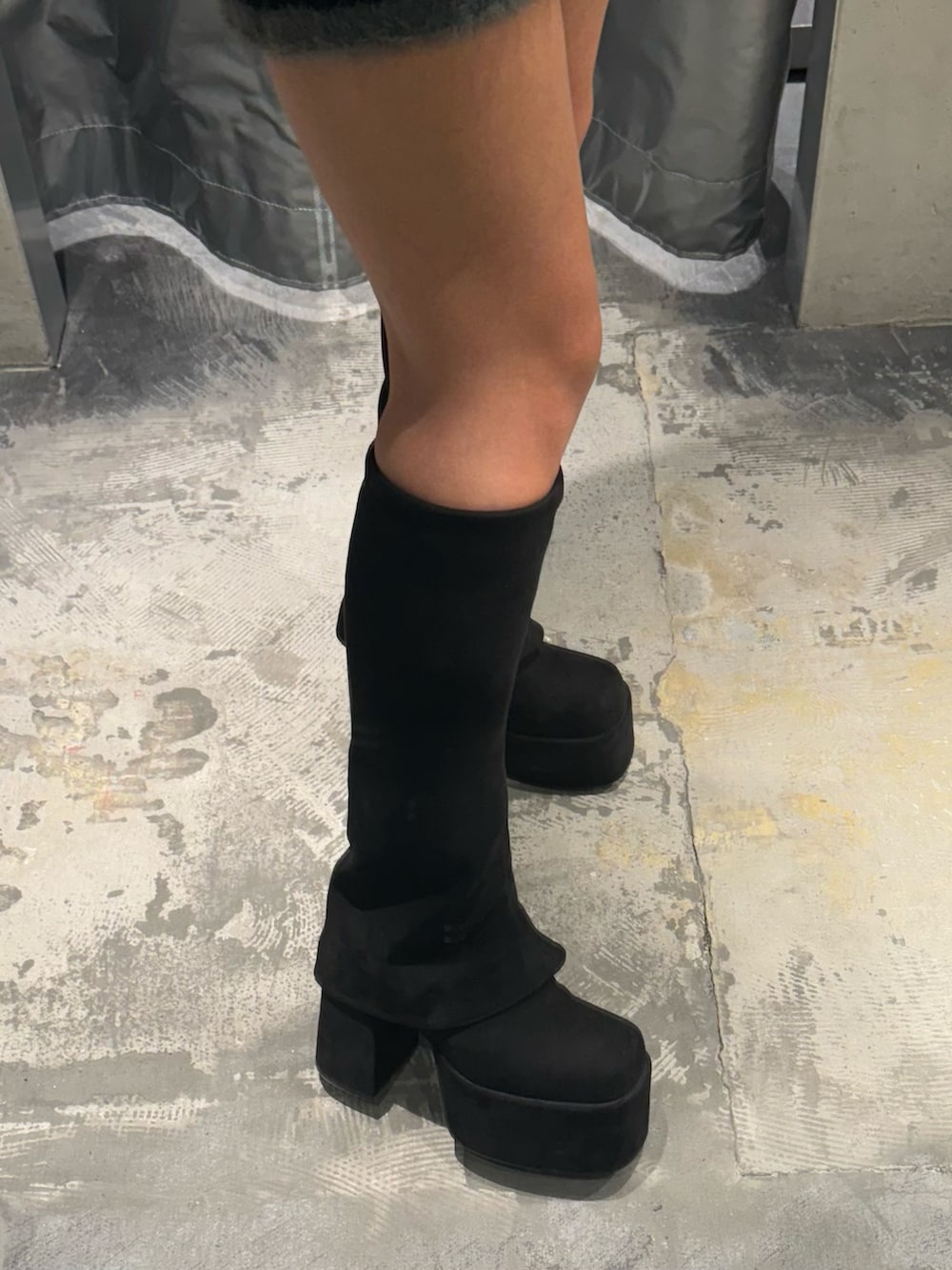 ブラック系のニット/セーター、ブラック系のスカート、ブラック系のブーツを着用したレディースの秋コーディネートの5枚目の写真