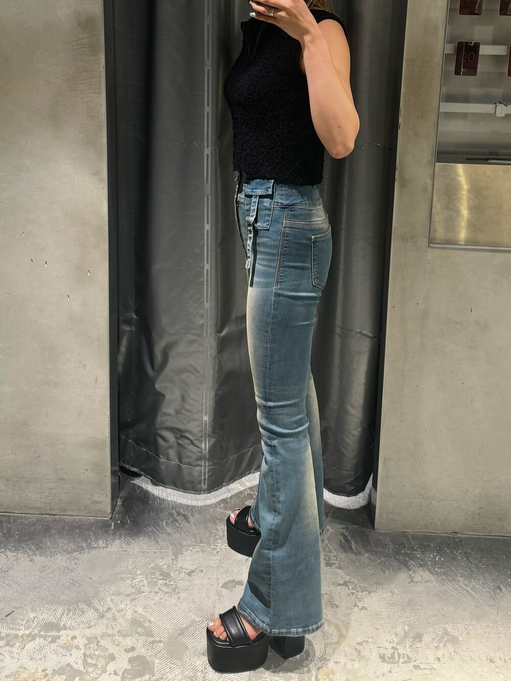 ブラック系のタンクトップ、ブルー系のデニムパンツ、ブラック系のサンダルを着用したレディースの夏コーディネートの2枚目の写真