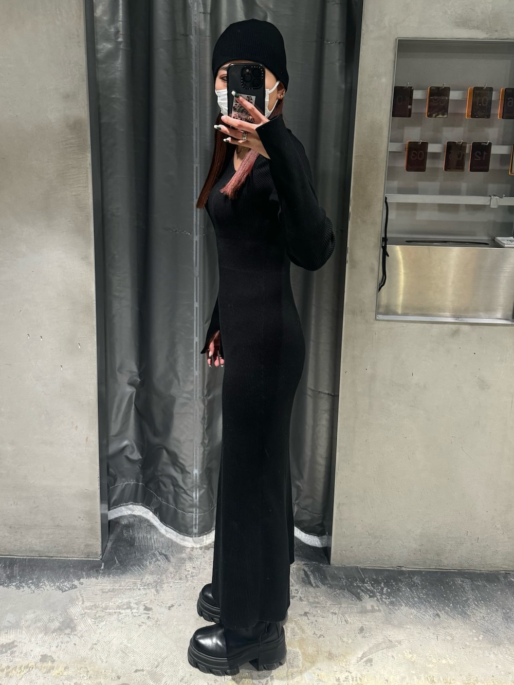 ブラック系のワンピース、ブラック系のブーツを着用したレディースの冬コーディネートの2枚目の写真