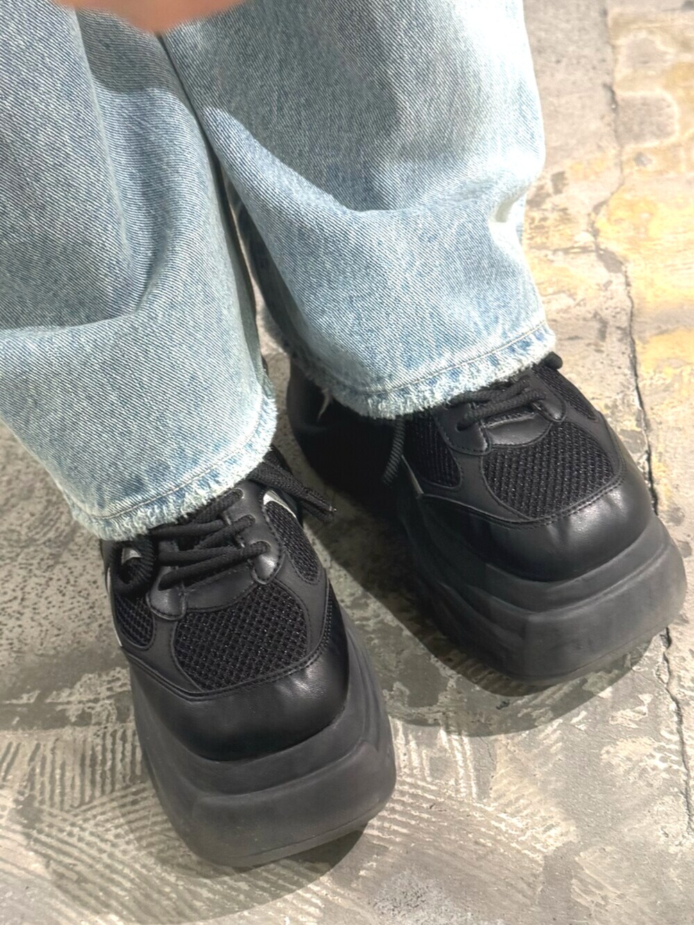 ブラック系のスニーカー、ブラック系のTシャツ/カットソー、ブラック系のデニムパンツを着用したレディースの春コーディネートの6枚目の写真