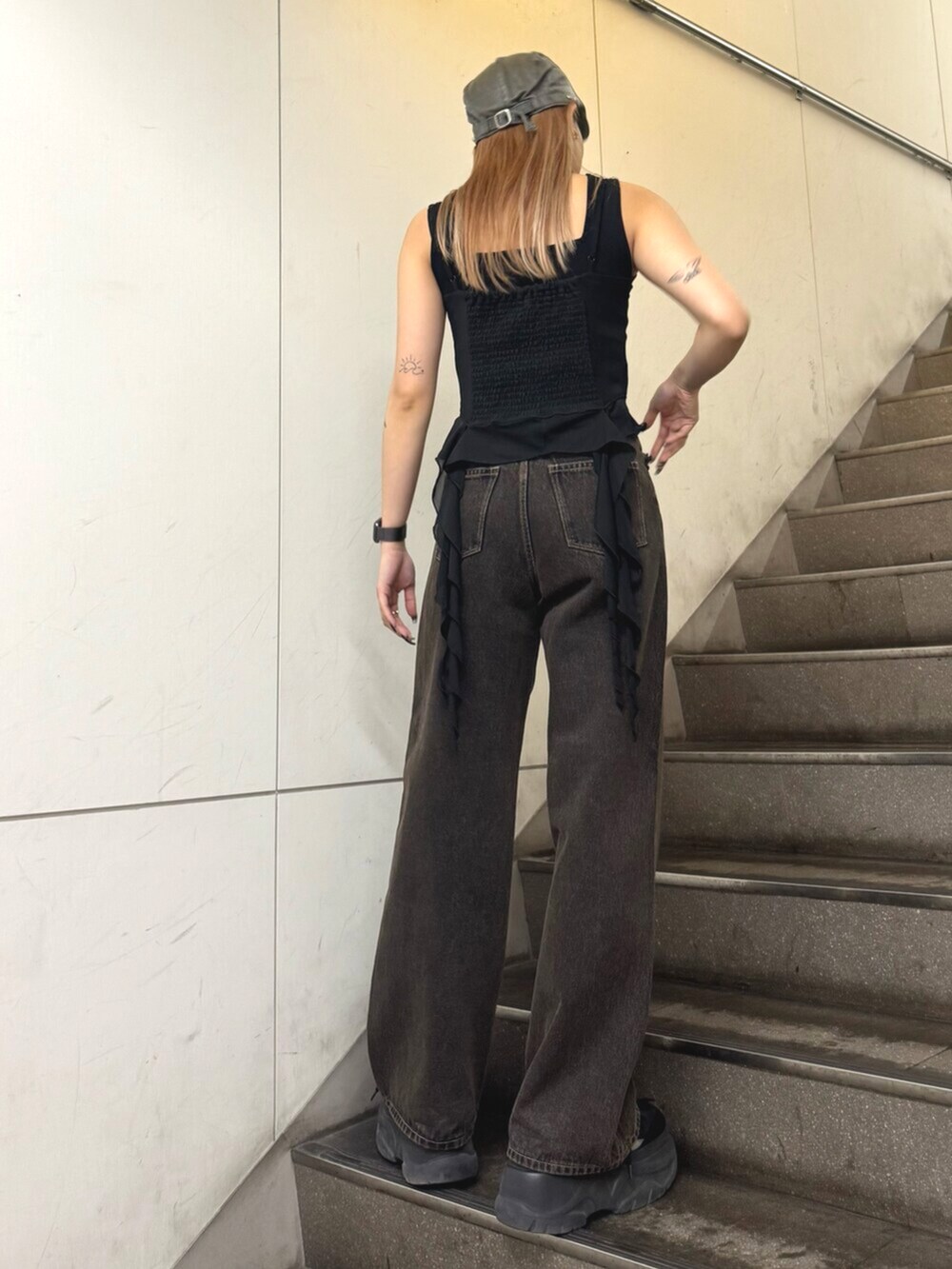 ブラック系のスニーカー、ブラック系のTシャツ/カットソー、ブラック系のデニムパンツを着用したレディースの春コーディネートの3枚目の写真