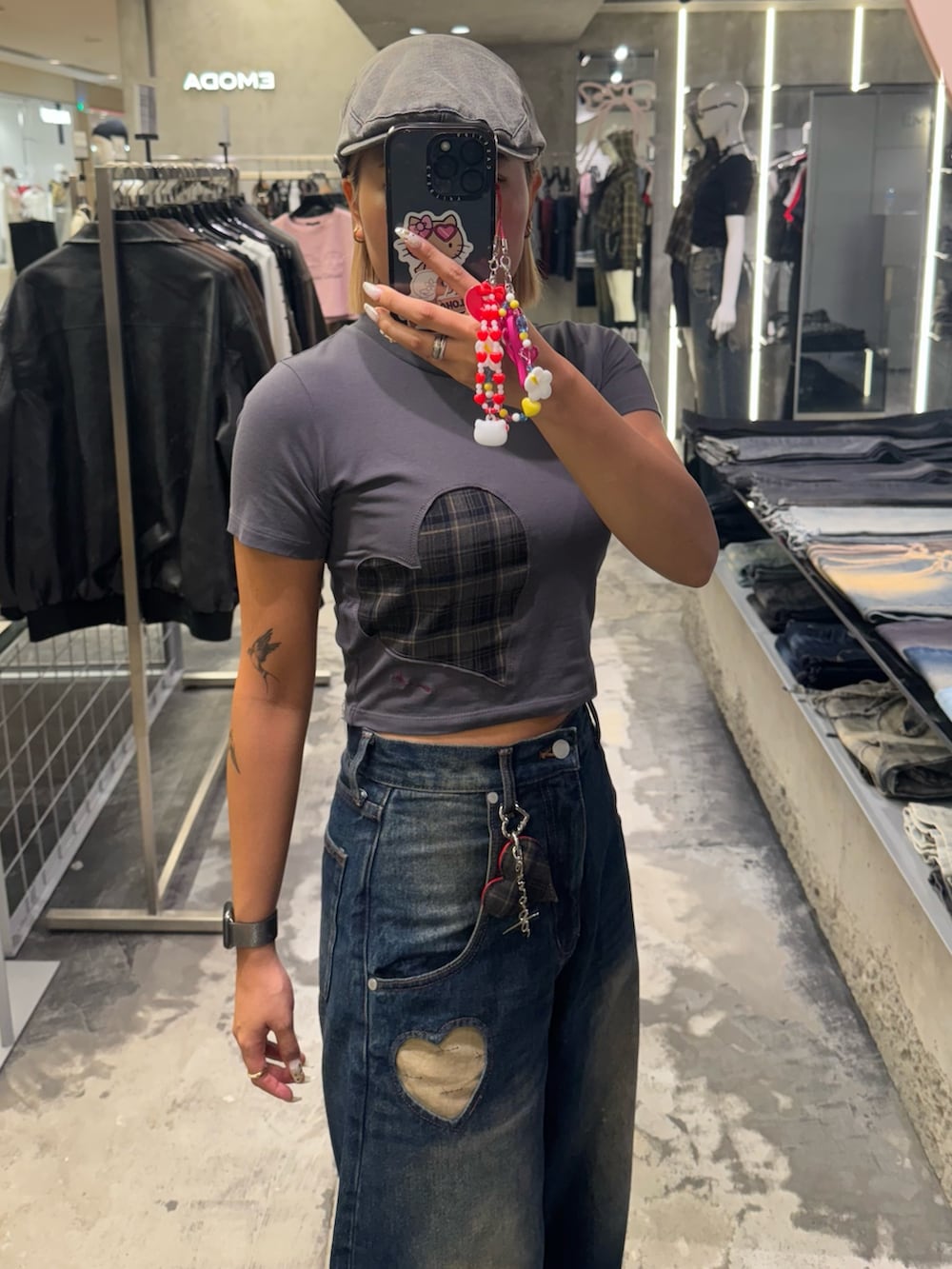 グレー系のTシャツ/カットソー、ブルー系のデニムパンツ、ブラック系のスニーカーを着用したレディースの秋コーディネートの4枚目の写真