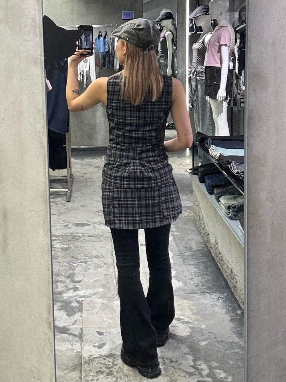 グレー系のワンピース、ブラック系のデニムパンツ、ブラック系のサンダルを着用したレディースの夏コーディネートの3枚目の写真