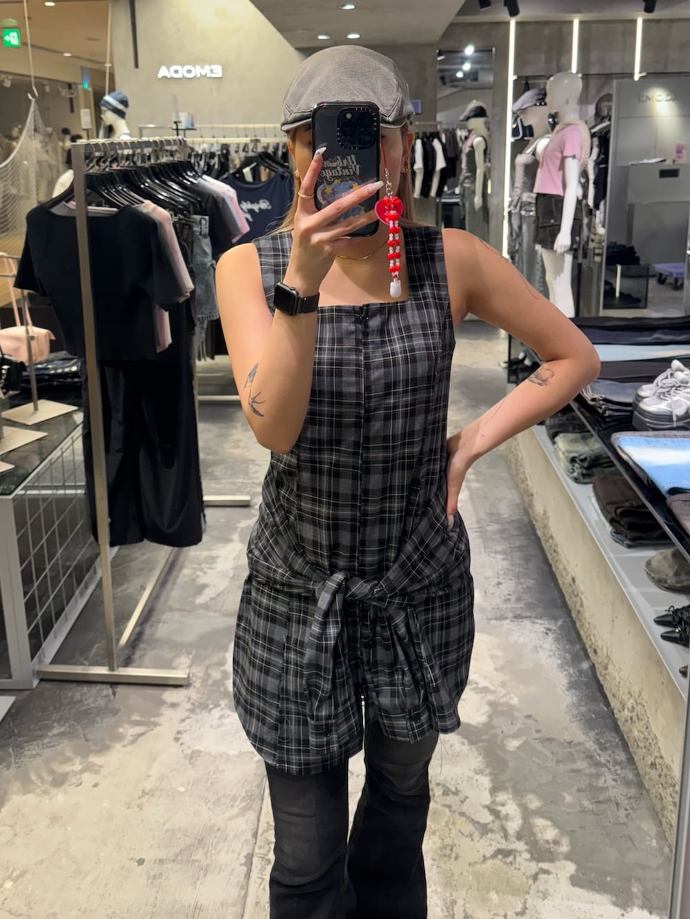 グレー系のワンピース、ブラック系のデニムパンツ、ブラック系のサンダルを着用したレディースの夏コーディネートの4枚目の写真