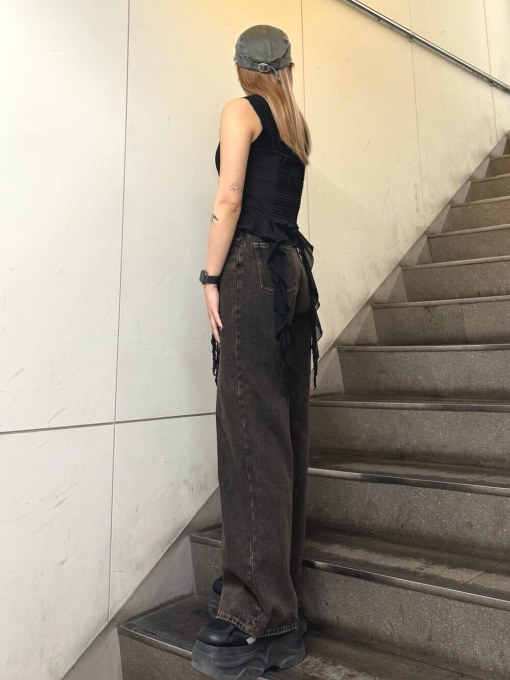 ブラック系のスニーカー、ブラック系のTシャツ/カットソー、ブラック系のデニムパンツを着用したレディースの春コーディネートの2枚目の写真