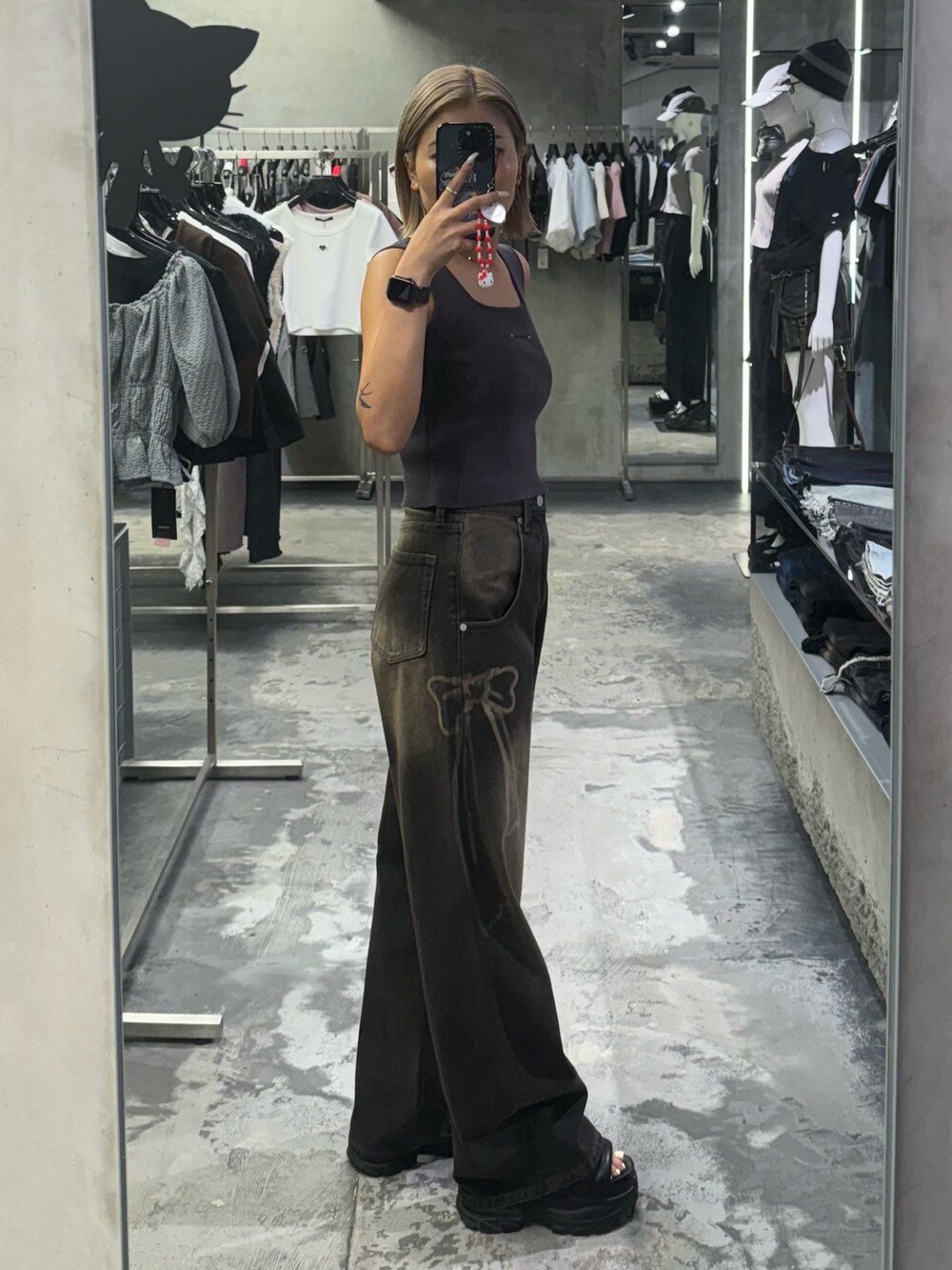 グレー系のTシャツ/カットソー、ブラック系のデニムパンツ、ブラック系のサンダルを着用したレディースの夏コーディネートの2枚目の写真