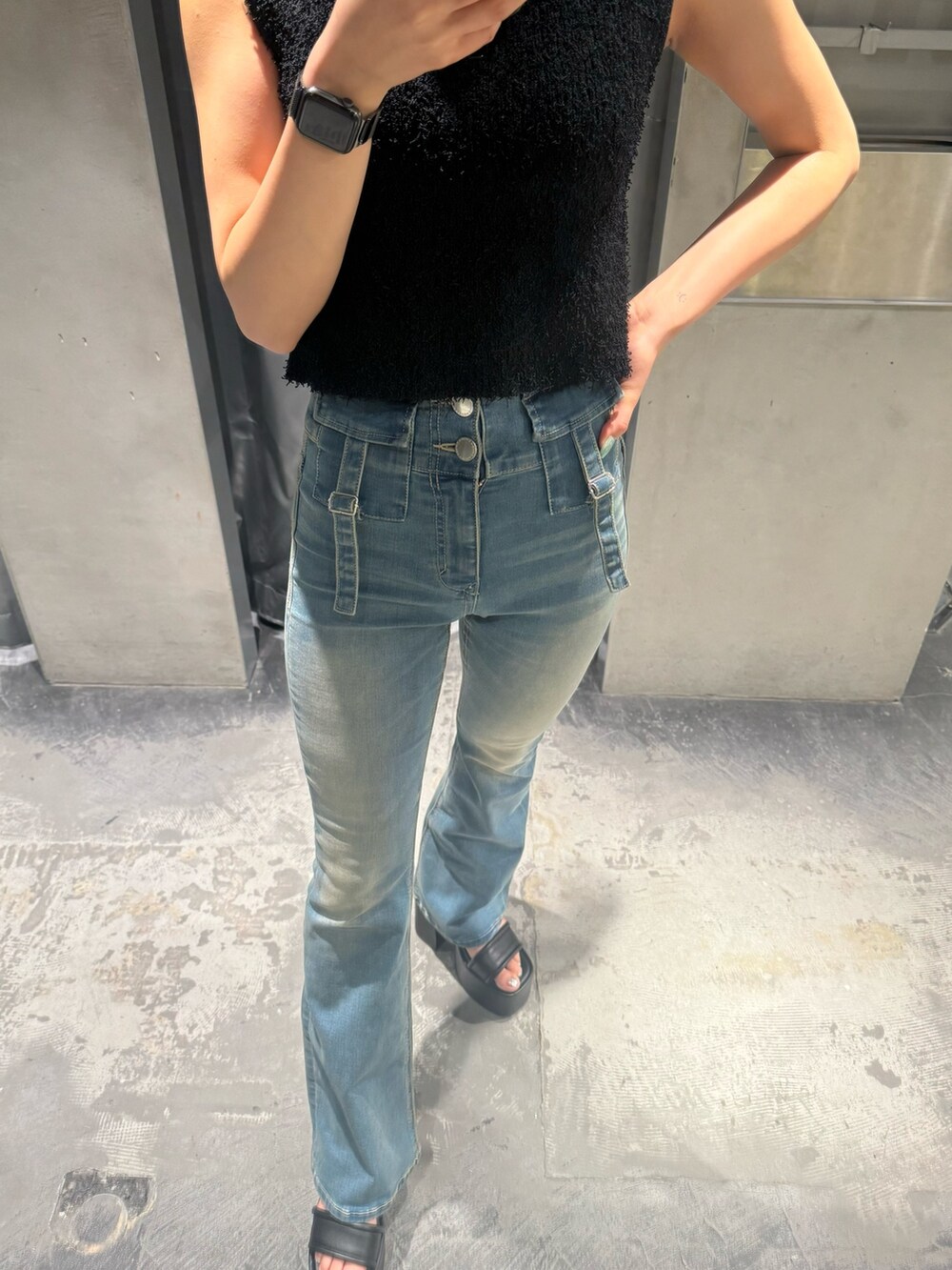 ブラック系のタンクトップ、ブルー系のデニムパンツ、ブラック系のサンダルを着用したレディースの夏コーディネートの6枚目の写真