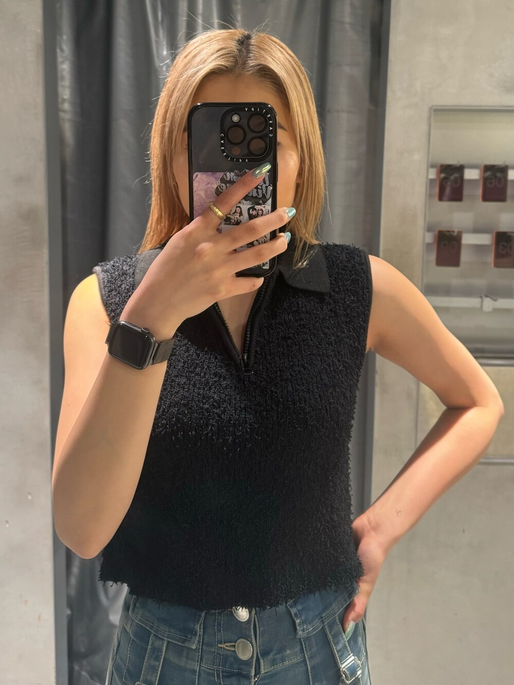 ブラック系のタンクトップ、ブルー系のデニムパンツ、ブラック系のサンダルを着用したレディースの夏コーディネートの4枚目の写真