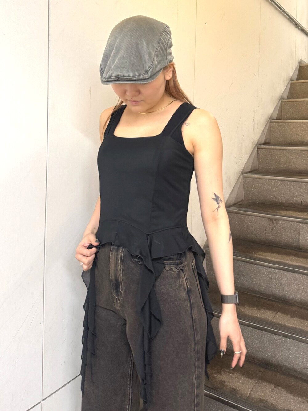 ブラック系のスニーカー、ブラック系のTシャツ/カットソー、ブラック系のデニムパンツを着用したレディースの春コーディネートの4枚目の写真