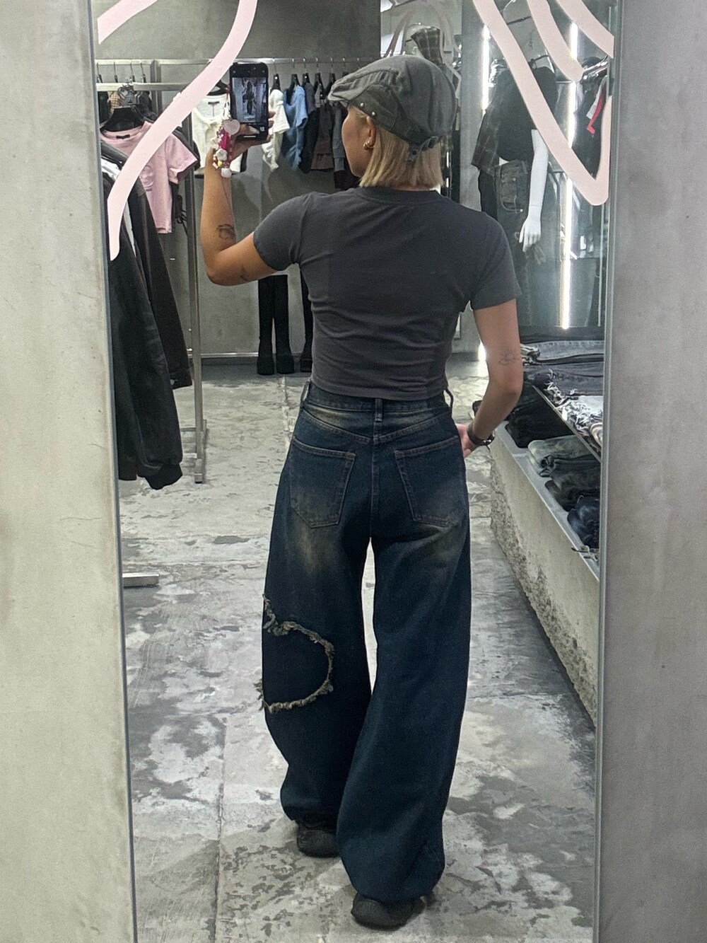 グレー系のTシャツ/カットソー、ブルー系のデニムパンツ、ブラック系のスニーカーを着用したレディースの秋コーディネートの3枚目の写真