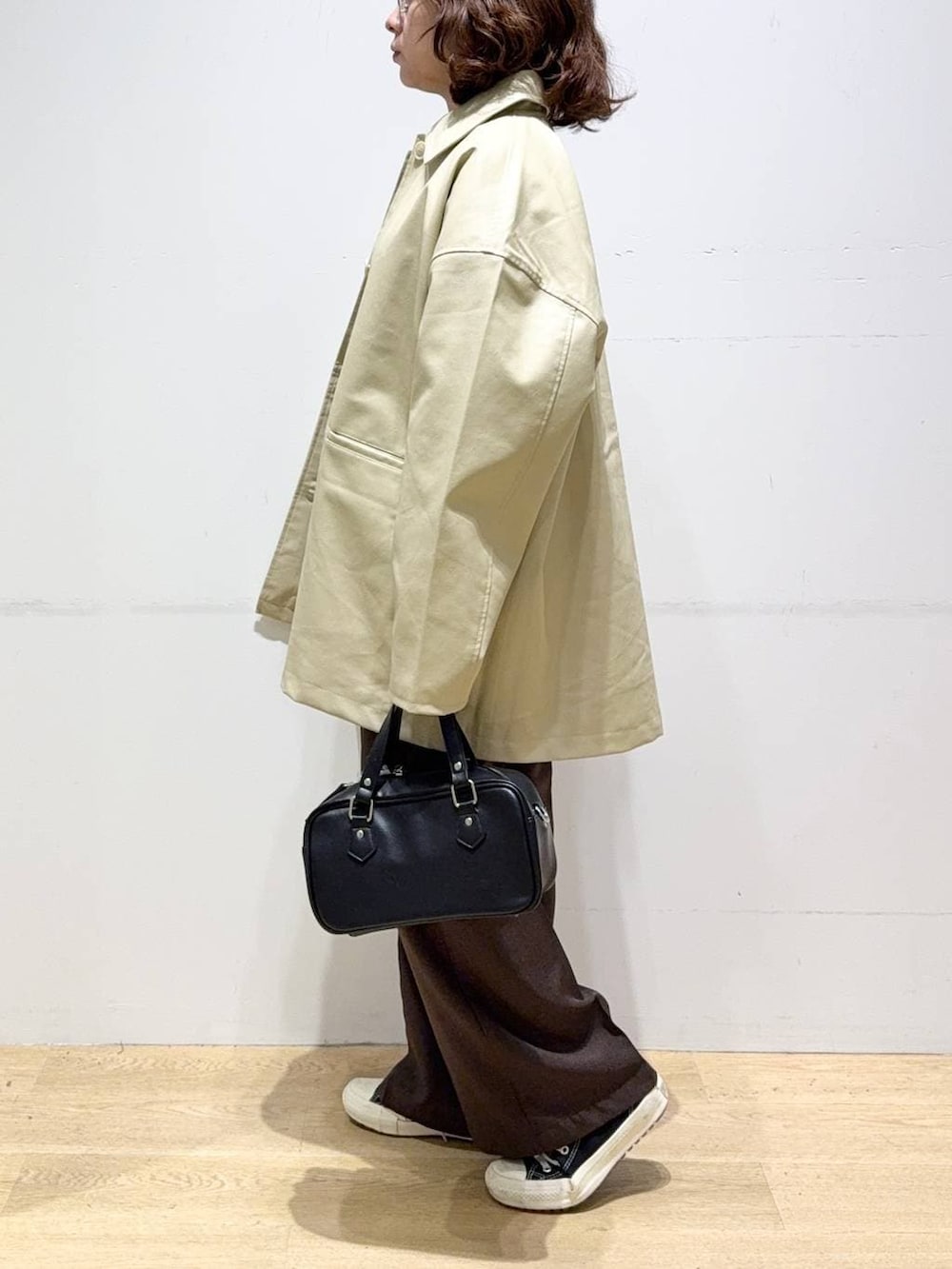 ベージュ系のステンカラーコート、ブラウン系のスラックス、グリーン系のシャツ/ブラウスを着用したレディースの秋コーディネートの5枚目の写真