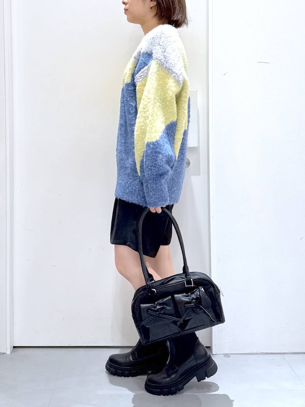 ブラック系のその他パンツ、ブラック系のハンドバッグ、ブラック系のブーツを着用したレディースの秋コーディネートの3枚目の写真