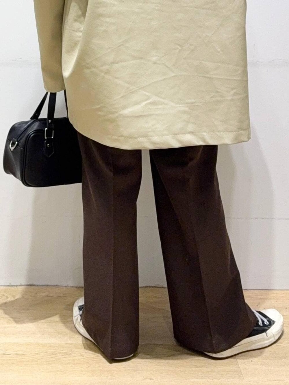 ベージュ系のステンカラーコート、ブラウン系のスラックス、グリーン系のシャツ/ブラウスを着用したレディースの秋コーディネートの8枚目の写真