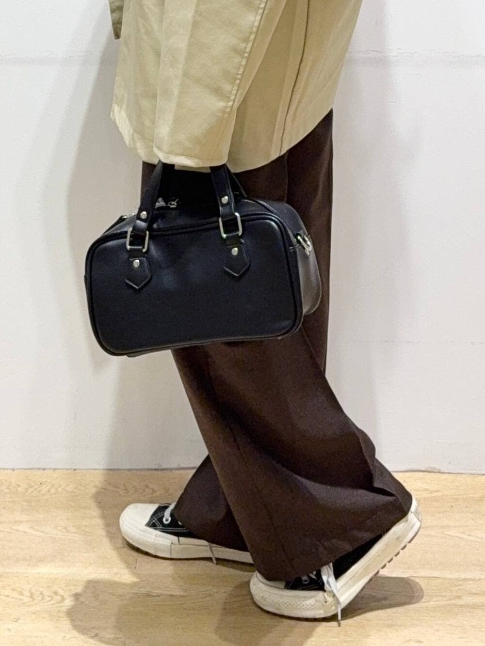 ベージュ系のステンカラーコート、ブラウン系のスラックス、グリーン系のシャツ/ブラウスを着用したレディースの秋コーディネートの9枚目の写真