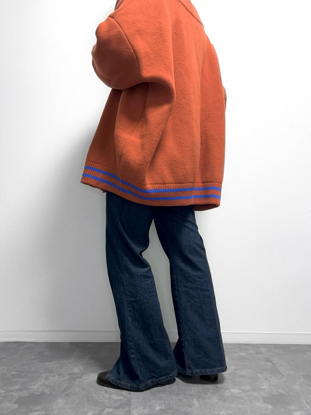 ブラック系のシャツ/ブラウス、オレンジ系のカーディガン/ボレロ、ブルー系のデニムパンツを着用したメンズの冬コーディネートの2枚目の写真