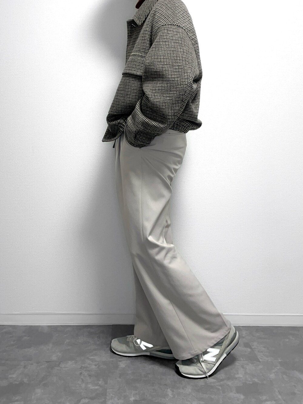 ベージュ系のブルゾン、グレー系のスラックス、グレー系のスニーカーを着用したメンズの冬コーディネートの2枚目の写真