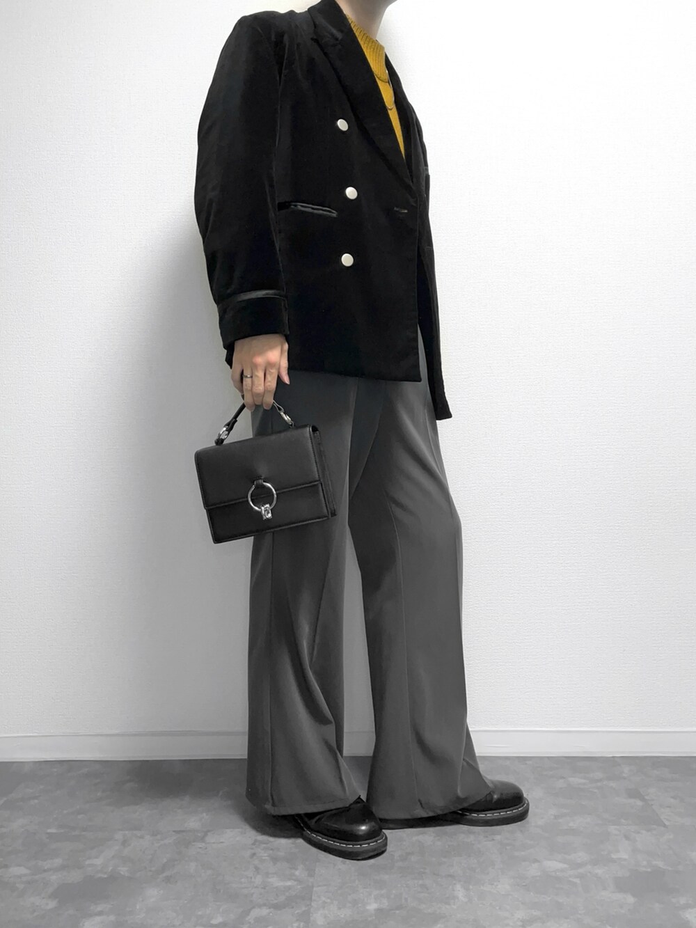 ブラック系のテーラードジャケット、グレー系のスラックス、イエロー系のニット/セーターを着用したメンズの冬コーディネートの2枚目の写真