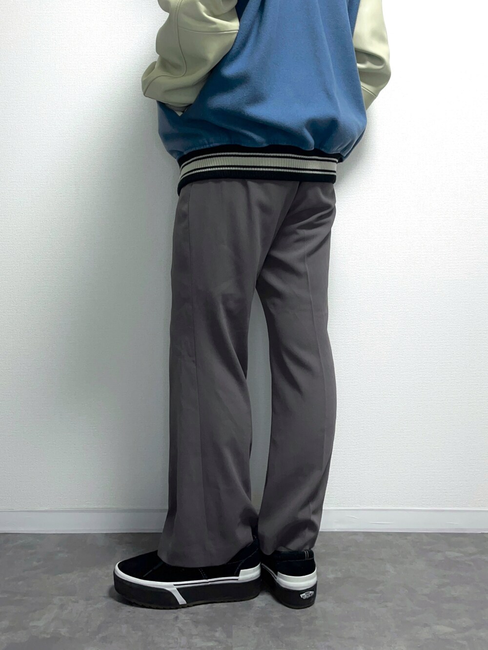 ブルー系のスタジャン、ブラック系のTシャツ/カットソー、ブラウン系のスラックスを着用したメンズの秋コーディネートの2枚目の写真