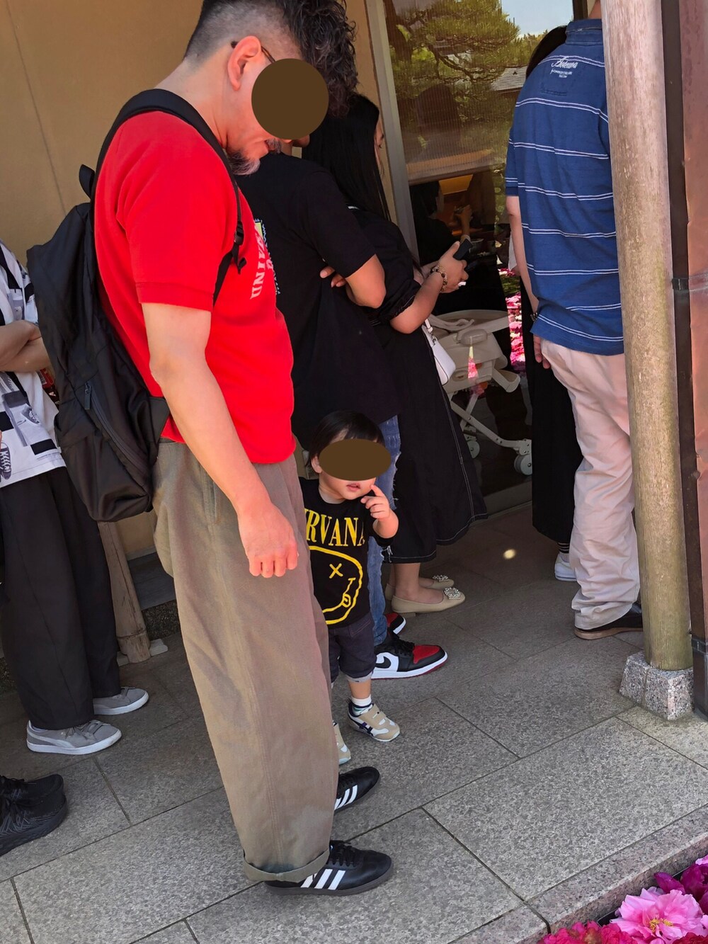 レッド系のスウェット、グレー系のパンツ、ブラック系のスニーカーを着用したメンズの春コーディネートの2枚目の写真