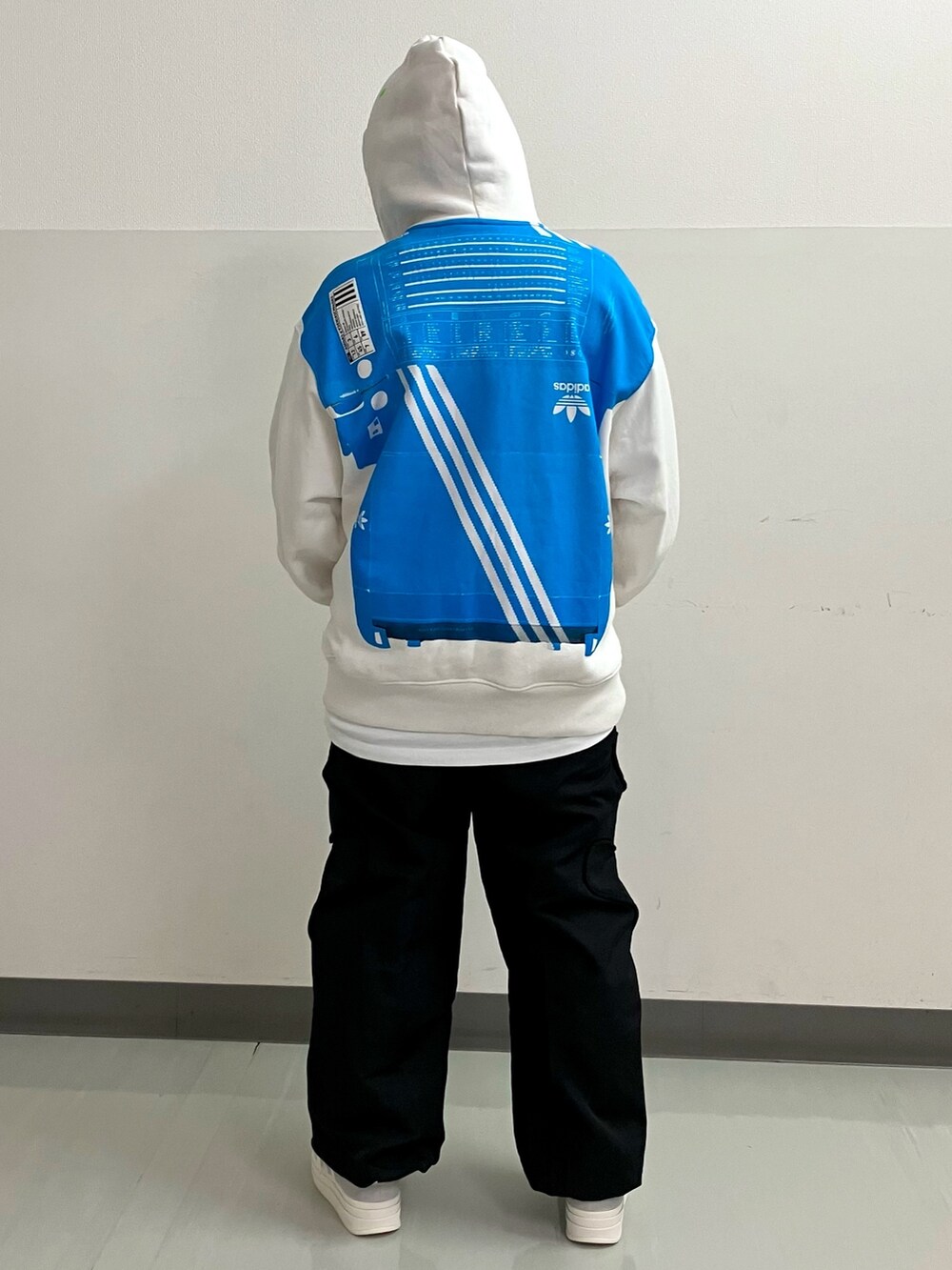 ホワイト系のトップス、ブラック系のその他パンツ、グレー系のスニーカーを着用したレディースの冬コーディネートの2枚目の写真